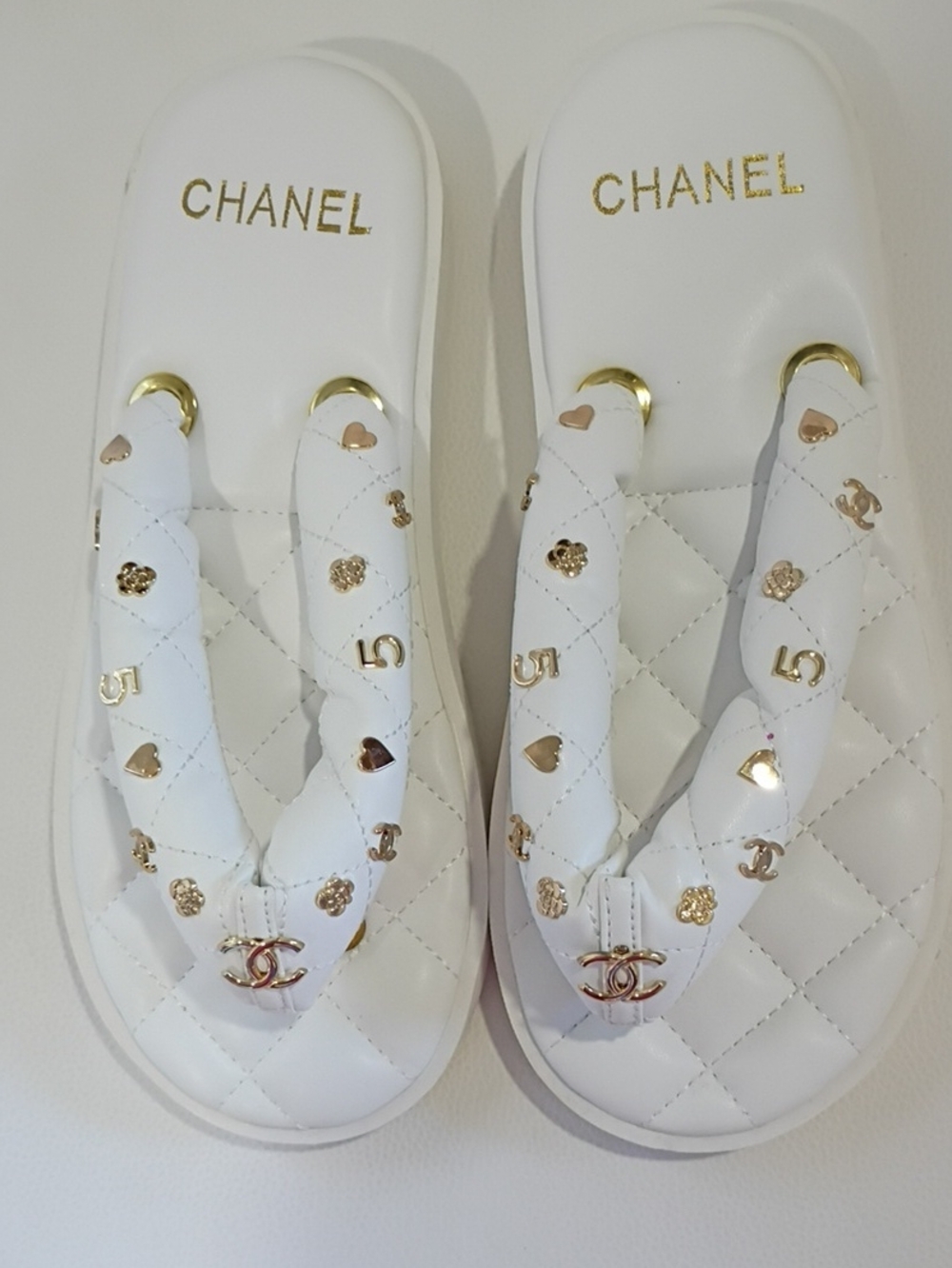 White Quilted Thong Sandals with Gold Accents and Logo Charms